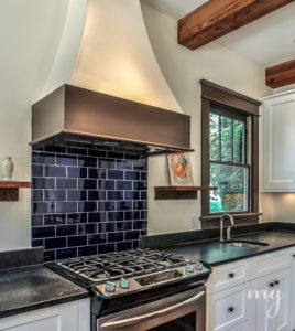 Open rustic shelving in kitchen. Cobalt blue subway tile.