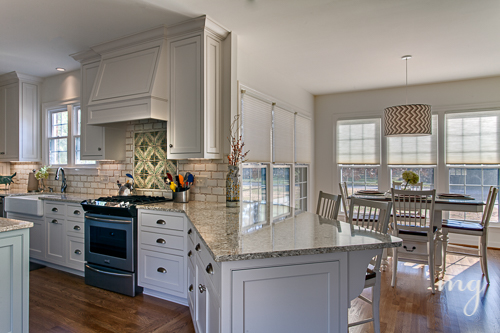 Features custom inset shaker style cabinets and oven hood with chevron patterned drum pendant